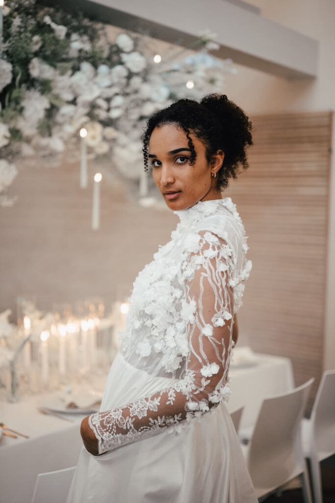 Braut mit natürlichen Locken und floral gearbeitetem Brautkleid im FREIgeist Northeim