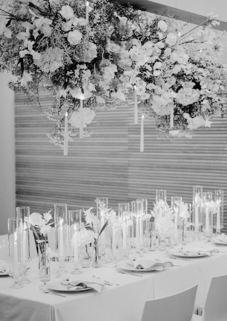 Festliche Hochzeitstafel mit hängender Blumeninstallation und zahlreichen Kerzen